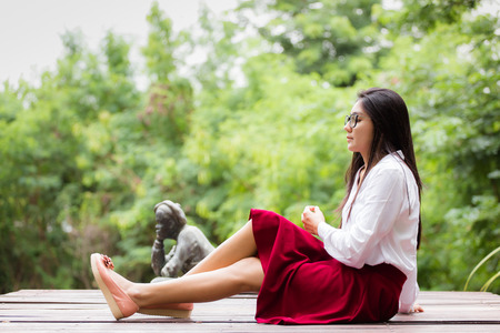 A portrait of a beautiful young asian woman wearing glasses in the parkの写真素材