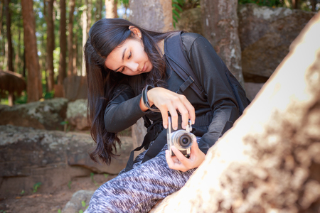 Beautiful asian woman with backpack taking a photo with mirrorless camera.の写真素材