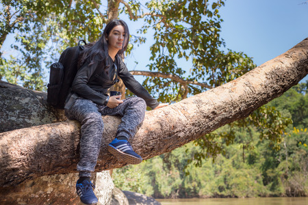 Beautiful asian woman with backpack taking a photo with mirrorless camera.