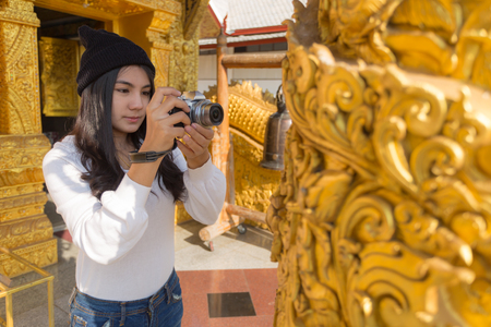 Asian woman taking photo with mirrorless camera at Wat Sri Phanton Buddhist Temple in Nan Province Northern Thailandの写真素材