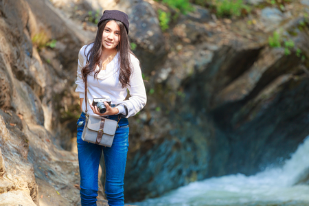 Beautiful asian woman hiking around mountains near the river at spring time with cameraの写真素材