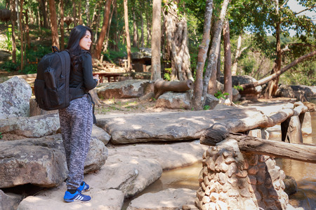 Beautiful asian woman with backpack taking a photo with mirrorless camera.の写真素材