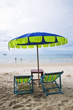Two beach chairs and colorful umbrella on perfect tropical beachの写真素材