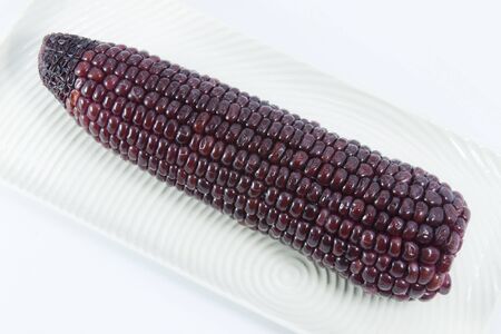 Tasty kitchen. Fresh corn isolated on white  plateの写真素材