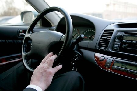 The man holds a rudder of the car
