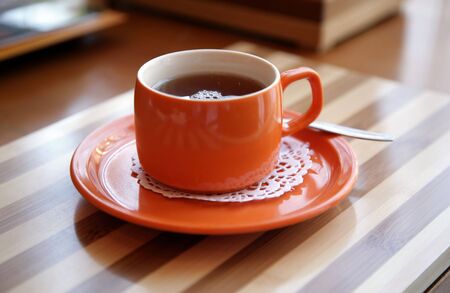Red cup with tea on a tableの写真素材