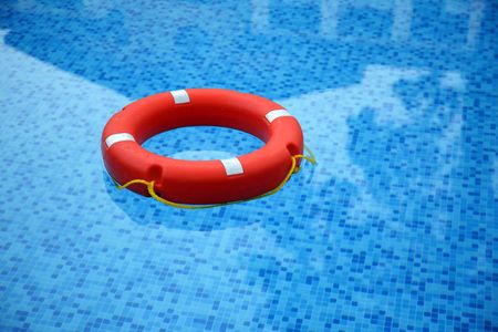 Red life buoy floating in swimming poolの写真素材