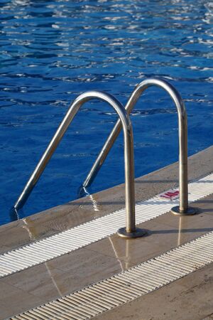 Fragment of pool with a ladder and transparent waterの写真素材