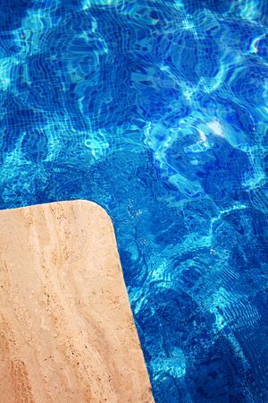 Edge of swimming pool and wave on a water surface