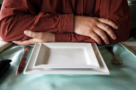 man having combined hands waits food at restaurantの写真素材