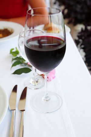 Glass with red wine on a tableの写真素材