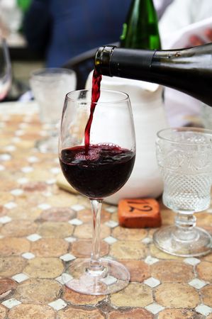 Red wine is poured in a glassの写真素材