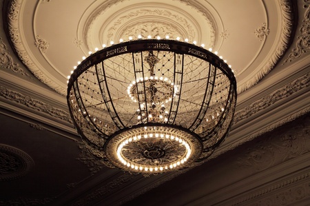 big beautiful chandelier on a ceiling with a stucco moldingの写真素材