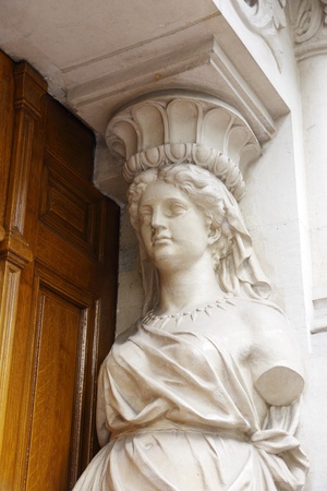 statue of a woman as a support on the building's facadeの写真素材