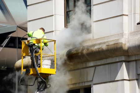 a worker washes the facade of the building a worker washes the facade of the building