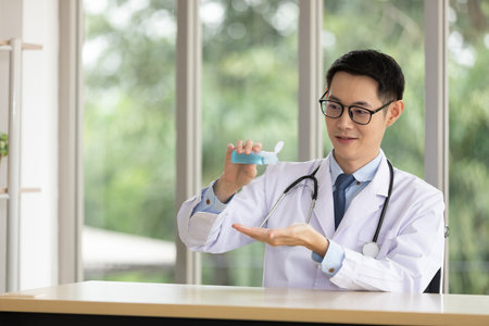young doctor explaining about film x-ray with patient or co-worker through online video chat from tablet in hospitalの写真素材