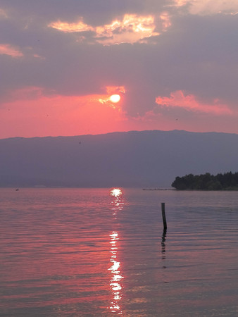Beautiful sunset over Ochrid lake. Reflection of the sun in the beautiful water of Lake Ochrid. Ochrid is the oldest lake in Europe. Travel and beauty in nature concept.の写真素材