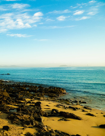 Canarian coast, beach, rocks, and Atlantic Ocean in Playa Blanca. Typical coast of Lanzarote island. Vacations and tourism concept.の写真素材