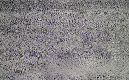 Tire tracks on gray ground as background. Offroad, nature and transportation concept.
