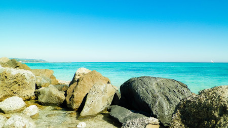 Stones on the beach in Vada, transparent, turquoise water and white sand. Travel and nature concept.の写真素材