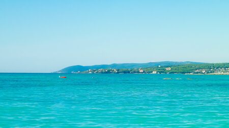 Coast in Italy in Vada, Tyrrhenian sea water on blue sky background. Vacations and nature concept....