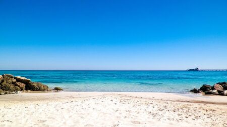 Stones on the beach in Vada, transparent, turquoise water and white sand. Travel and nature concept.