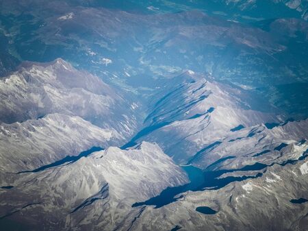 Alps, view of the mountains from the window of the plane. Land bending and nature concept.の写真素材