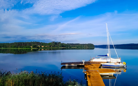 Sailing on Lake Wdzydze. A sailboat moored at the shore of the lake. Wdzydze is one of the largest...