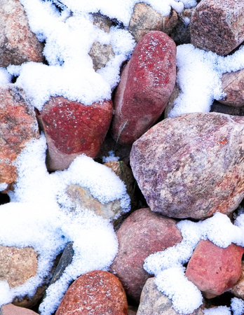 Snow on stones as nature background. Beginning of winter.の写真素材