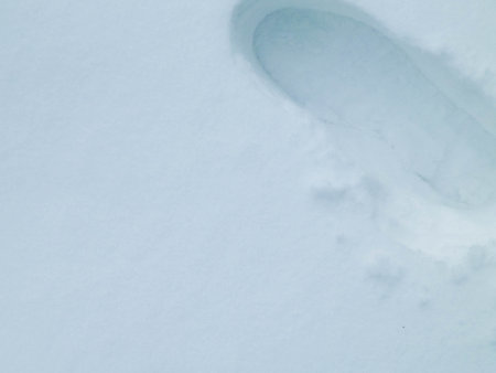 Nature background - shoe footprint in fresh snow. Copy space, exploration concept.の写真素材