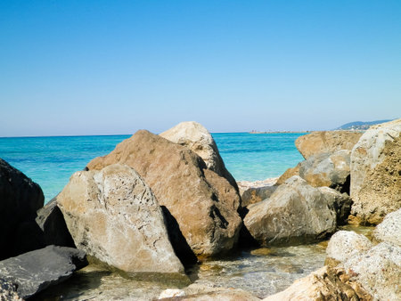Stones on the beach in Vada, transparent, turquoise water and sand. Travel and nature concept.の写真素材