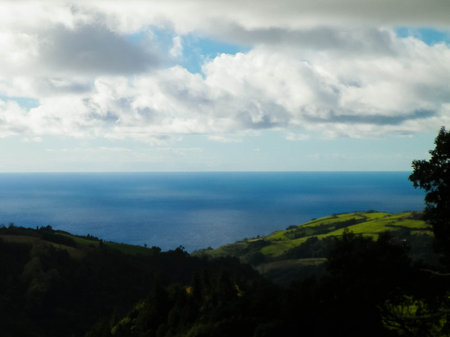 Typical landscape of Azores. Natural green fields hills and sea in a background. Beauty of nature concept.の写真素材