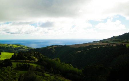 Typical landscape of Azores. Natural green fields hills and sea in a background. Beauty of nature concept.の写真素材