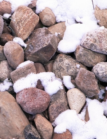 Snow on stones as nature background. Beginning of winter.の写真素材