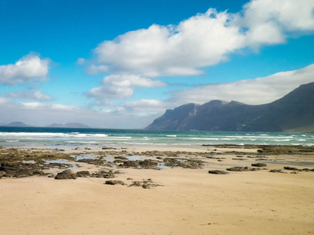 Sandy beach Caleta de Famara on the island of Lanzarote. Canaries. An iconic place among surfers.の写真素材