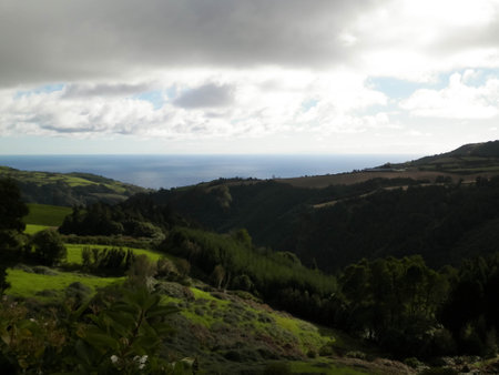 Typical landscape of Azores. Natural green fields hills and sea in a background. Beauty of nature concept.の写真素材