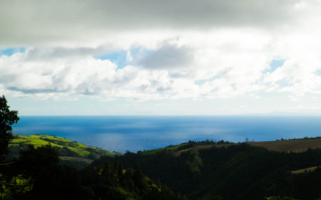 Typical landscape of Azores. Natural green fields hills and sea in a background. Beauty of nature concept.の写真素材