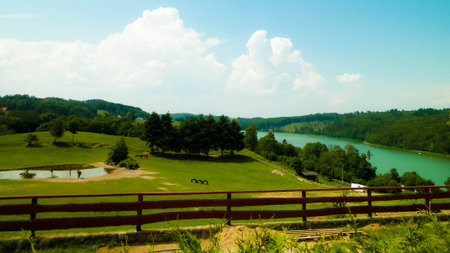 Rural landscape of Wiezyca region in Kashubia, Poland. Pastures, meadows and Ostrzyckie lake in background.の写真素材
