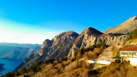 Sunny day over Lovocen Mountain tops and Kotor Bay fjords. The Lovcen Mountains lie around Boka Kotorska in Montenegro. Kotorska bay in a foreground.の写真素材