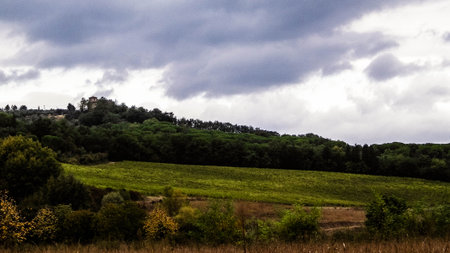 Autumn in Italy - Tuscan fields and hills on a cloudy day. Copy space on cloudy sky.の写真素材