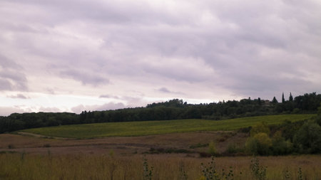 Autumn in Italy - Tuscan fields and hills on a cloudy day. Copy space on cloudy sky.の写真素材