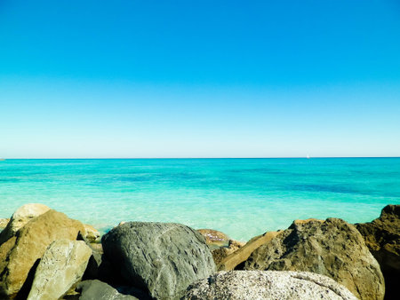 Stones on the beach in Vada, transparent, turquoise water and white sand. Travel and nature concept.の写真素材