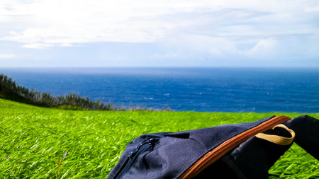Backpack on meadow. Sao Miguel Island. Azores. Travel and nature concept.の写真素材