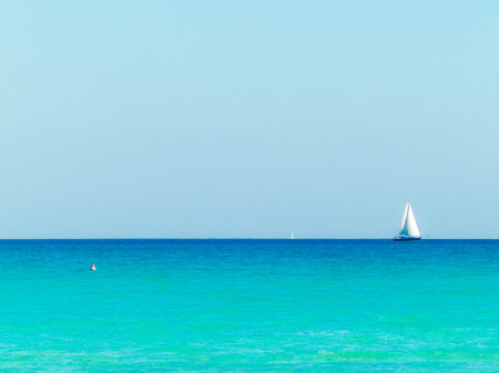A boat in the turquoise waters of the Mediterranean Sea. Copy space on blue sky. Travel and leisure concept.の写真素材