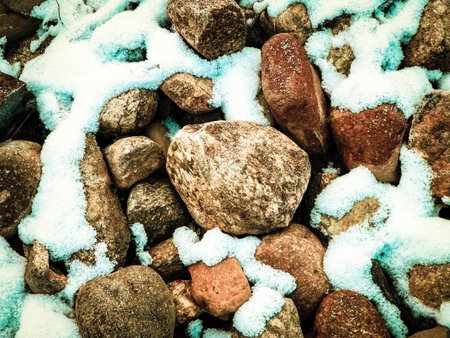 Snow on stones as nature background. Beginning of winter.の写真素材