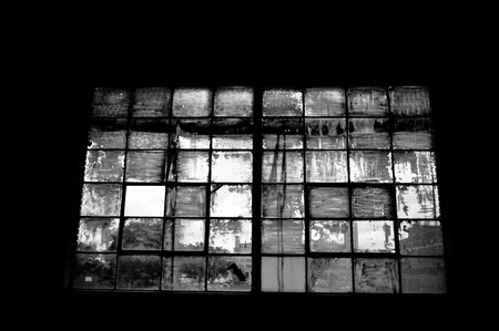 Old broken window in an abandoned warehouse