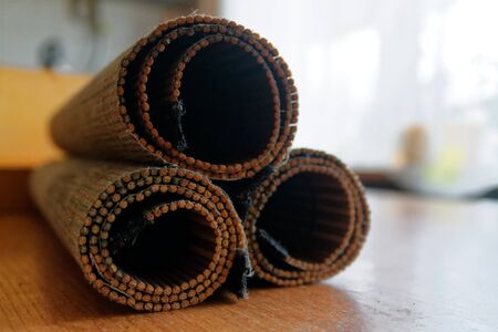 Rolled Bamboo litter on a wooden table textureの写真素材