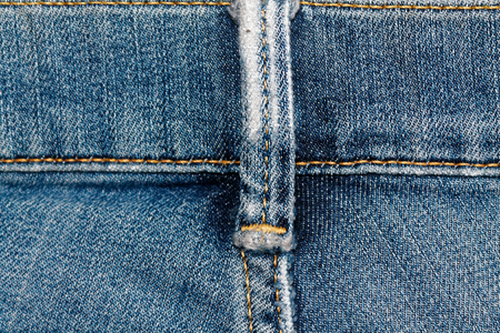 Closeup of obsolete blue jeans pocket Denim texture, macro background for web site or mobile devicesの写真素材