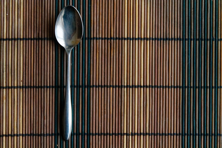 Metal vintage spoon on a wooden bamboo tableの写真素材