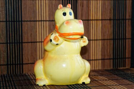 Piggy bank isolated on wooden texture. Money box looks like hippoの写真素材